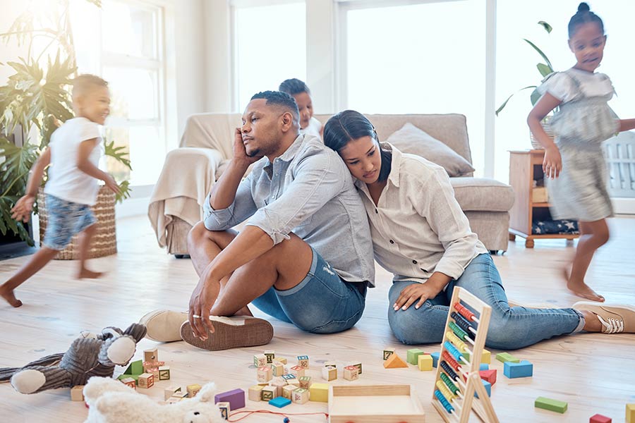 Parents fatigués par leurs enfants qui jouent dans le salon